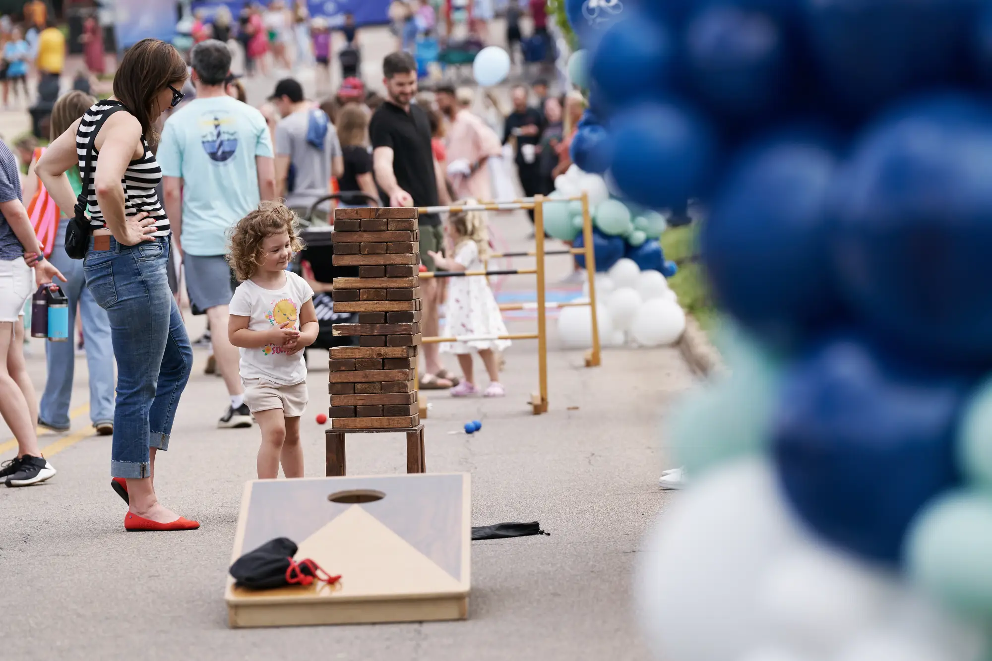 Little girl looking at Jinga game with her mom