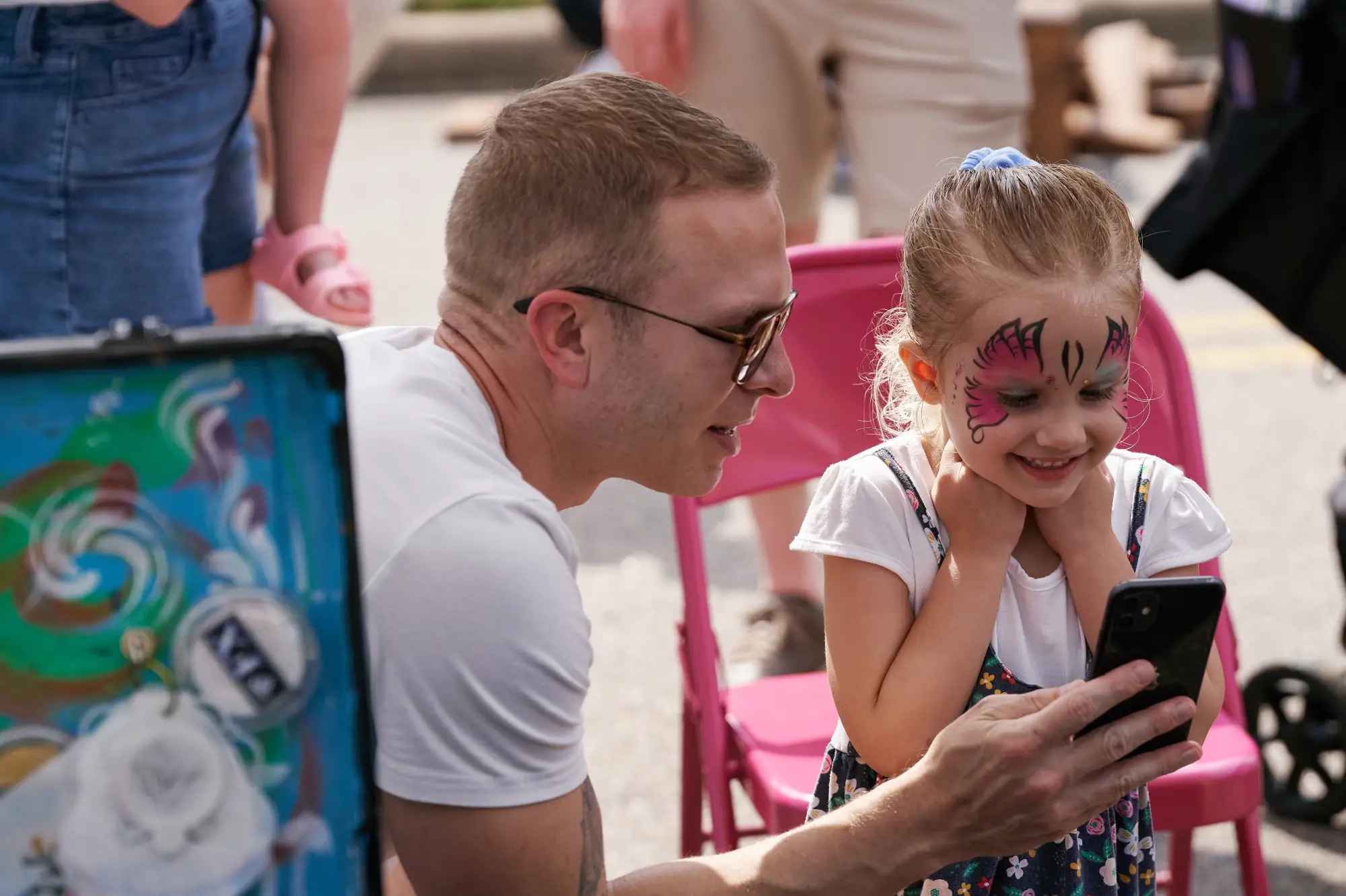 little girl with her dad looking at her face paint