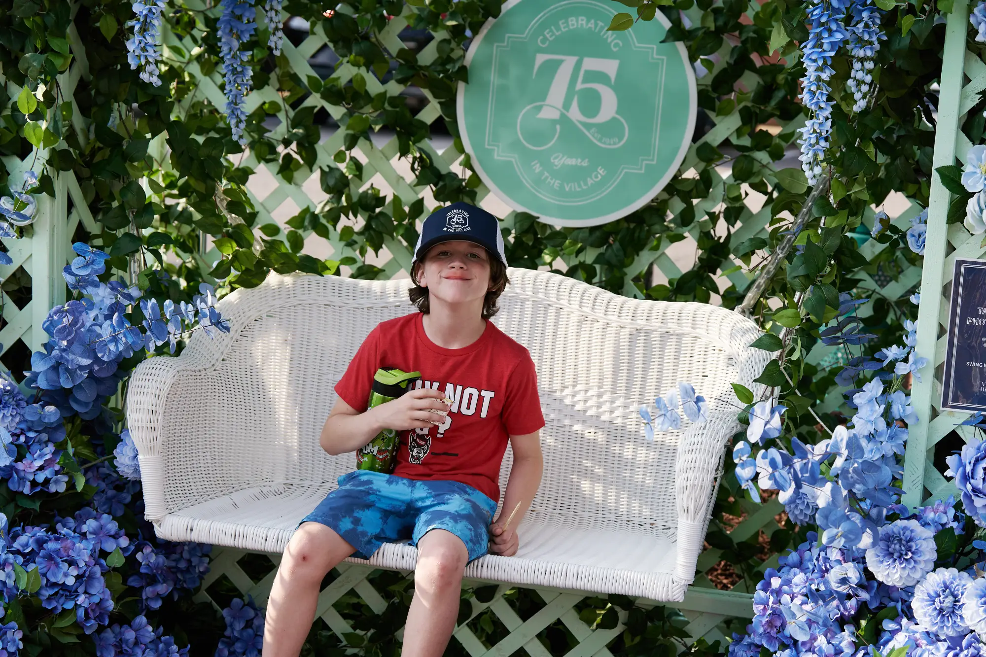 little boy on swing surrounded by flowers