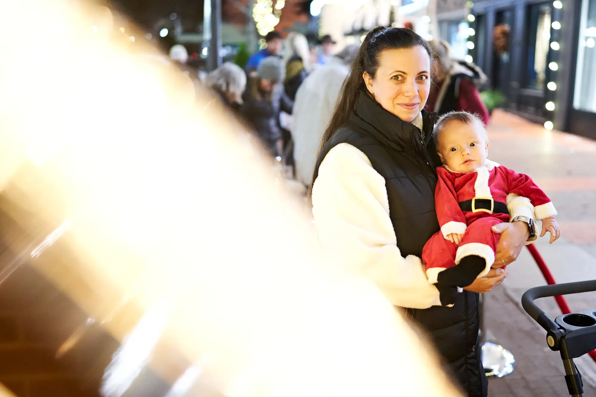woman holding baby in Santa outfit